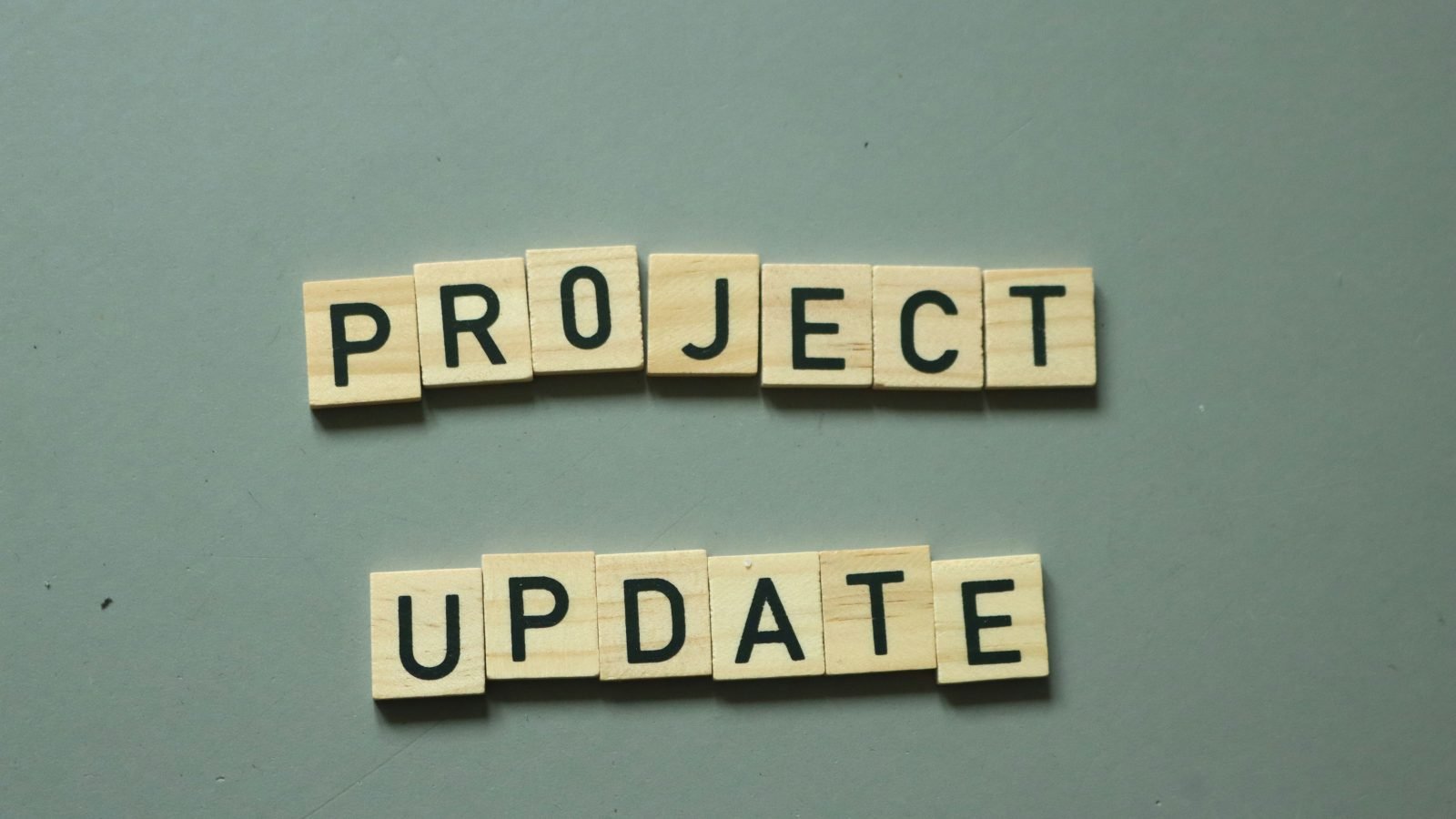 Project update tiles on desk, illustrative for an Asana review.