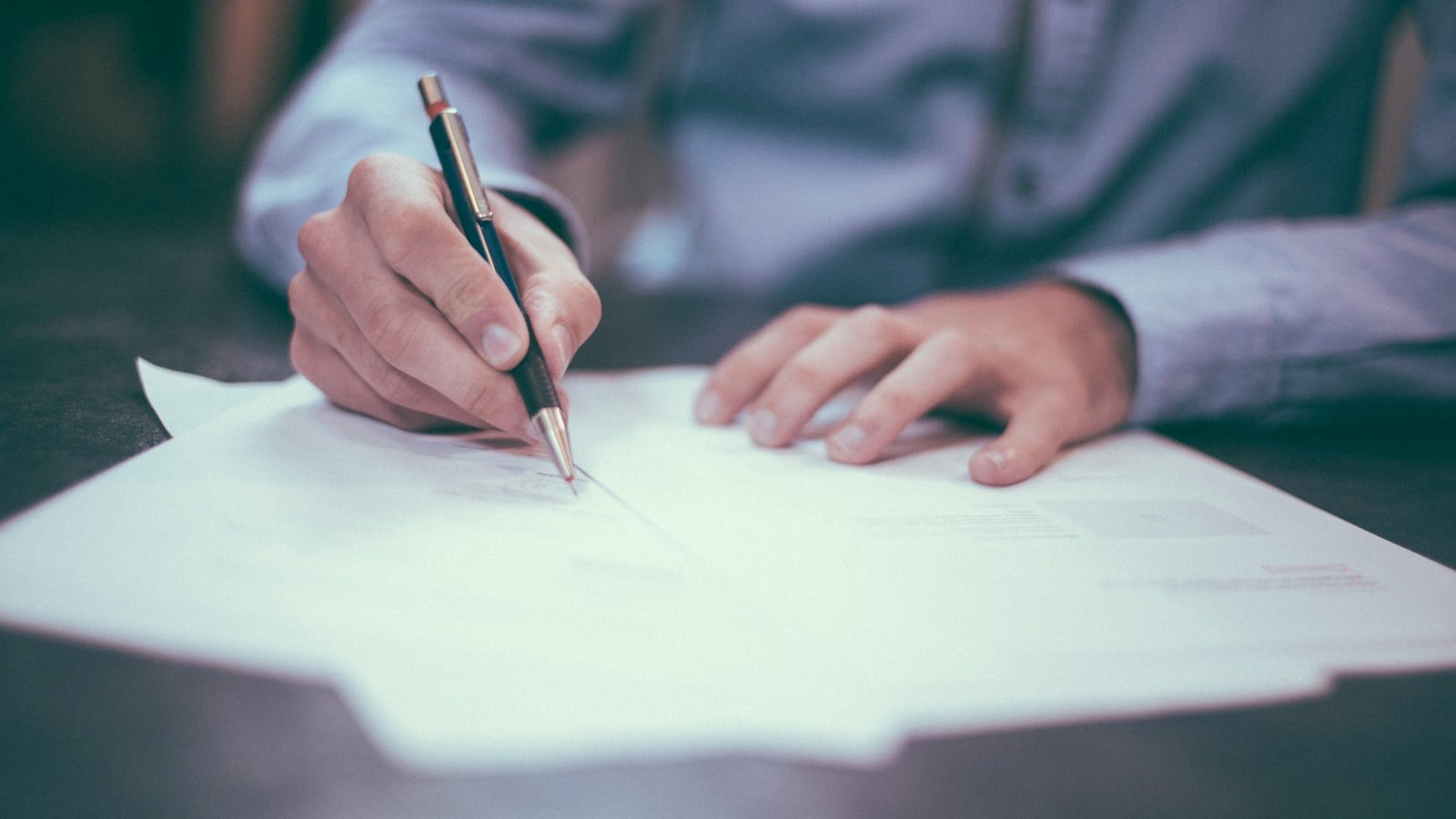 Pen signing document evoking contract signatures and agreements