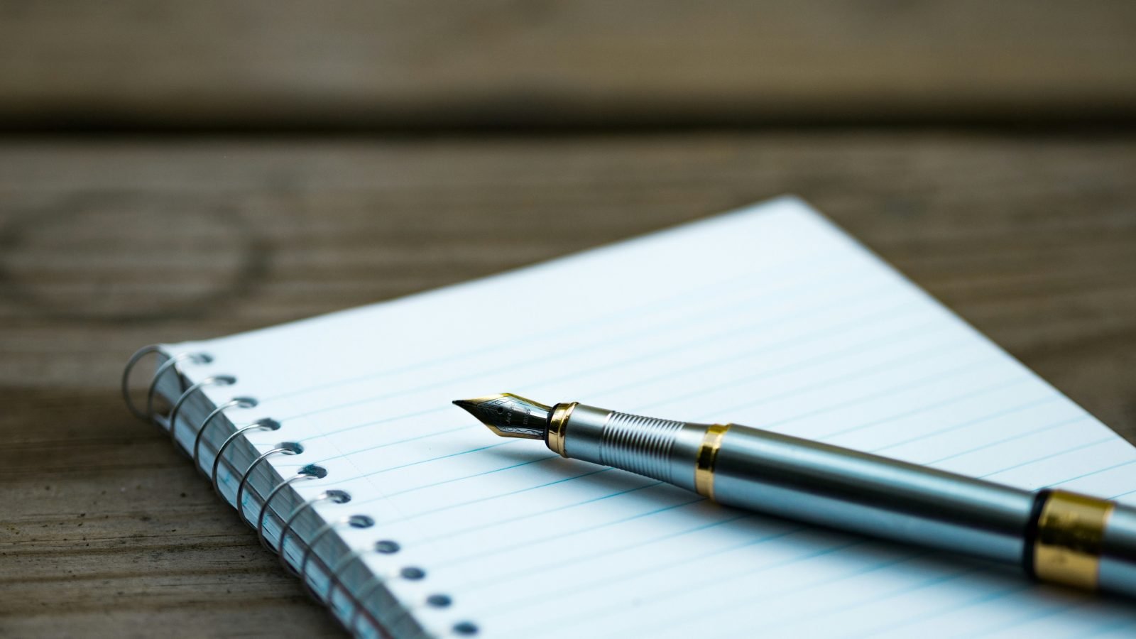 Pen and notebook on desk, evoking thoughtful writing and editing