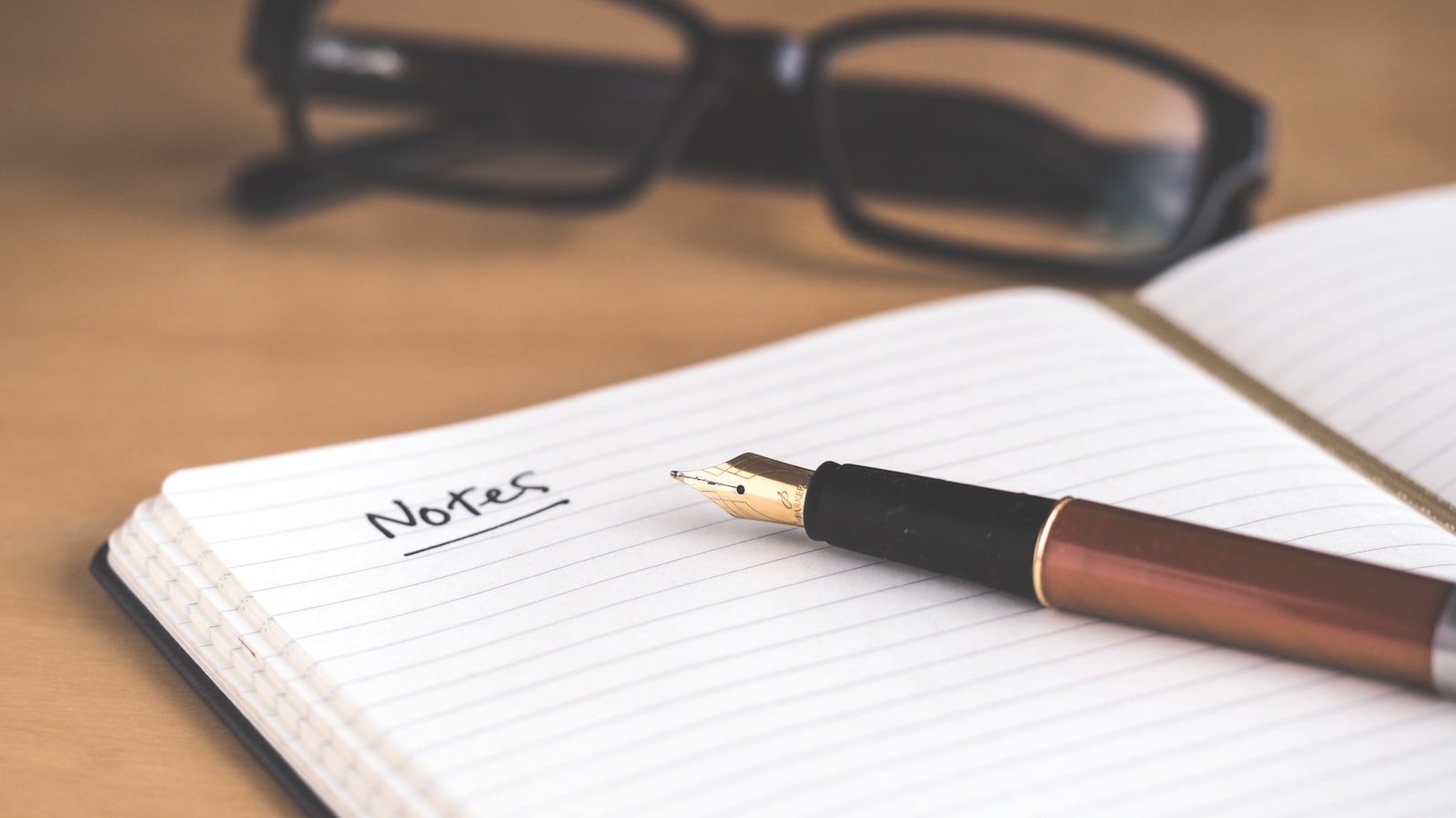Clean notebook and pen on desk, evoking Notion's writing-first workspace